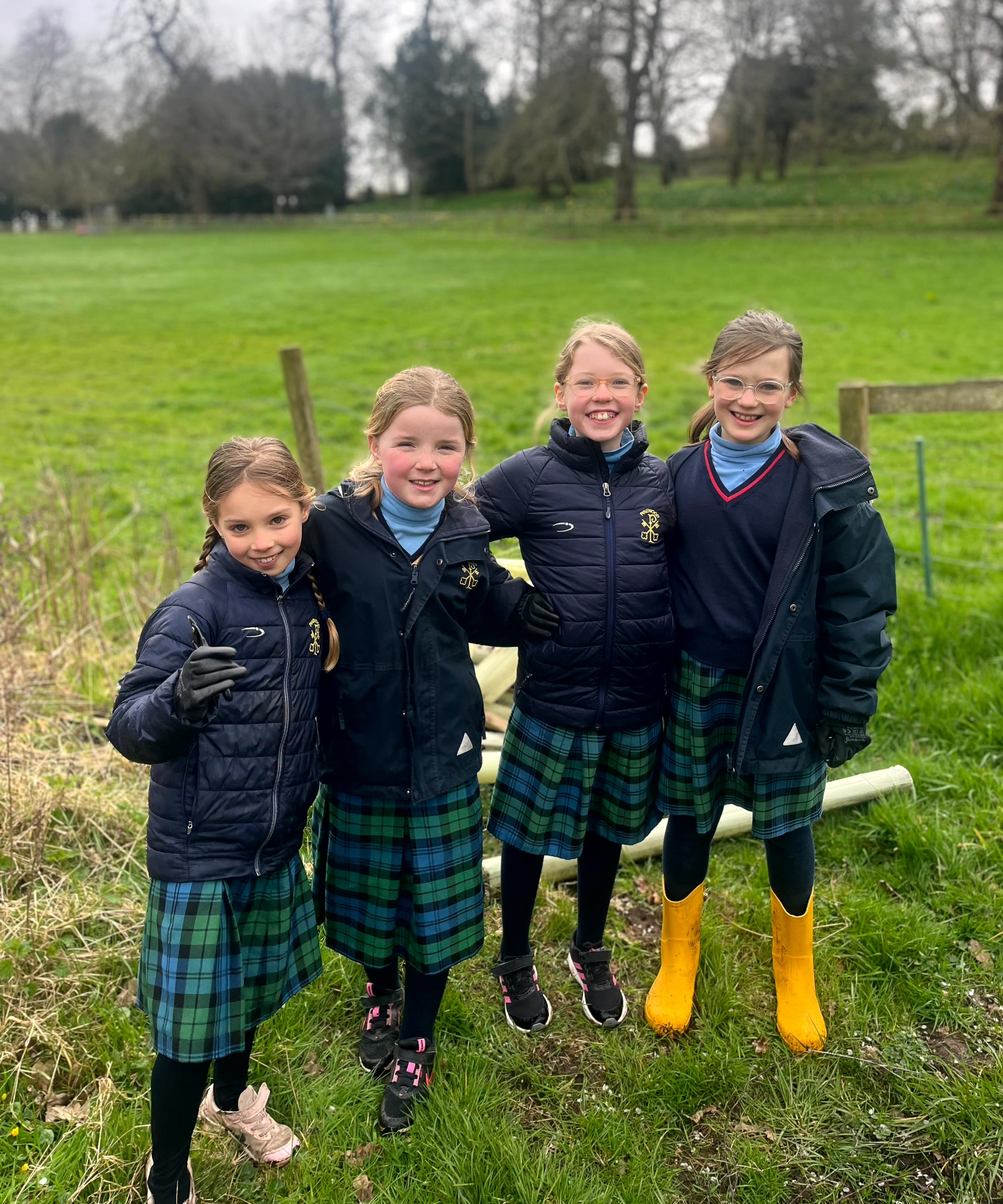Four school girls outdoors smiling at the camera
